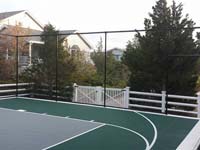 Slate green and titanium tiled basketball court with fencing in Plymouth, MA.