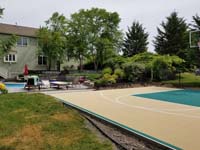 Off-white, tan, sand, beige, ecru? Whatever you call it, looks great with green on a home basketball court in Easton, MA, featuring view of existing pool in background.