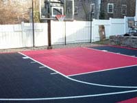 Small black and red basketball court installed in Hingham, MA in early spring.