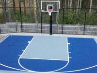 Residentiall half court with basketball hoop and rebound fence in Kingston, MA, in navy and ice blue colors.