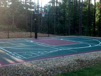 Residential basketball court with shuffleboard, fence and goal system in Kingston, MA.