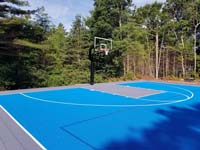 Large royal blue and titanium commercial basketball court with golf seahorse logo at Bay Club in Mattapoisett, MA.