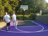 Catchy purple and black residential basketball court in Stoneham, MA takes advantage of a small, unused space in the yard.