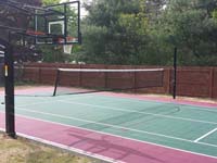 Residential basketball and tennis installation in Sudbury, MA, focusing on tennis net that uses basketball goal post as one of its supports.