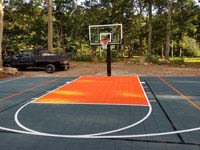 Graphite and orange residential basketball court replacing a dead pool in Walpole, MA.