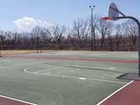 Resurfaced municipal basketball courts in Walpole, NH to create a combo of pickleball and basketball on comfortable, durable royal blue and graphite versacourt tile. This shows part of the old court that was replaced.