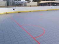 Photo from Scottsdale, Arizona installation of inline skating hockey rink for NHL Coyotes and the Boys and Girls Club, at Laguna Elementary. Removal of old surface, prep, installation of Versacourt IceCourt Outdoor Speed tile, and finished surface with custom logos.